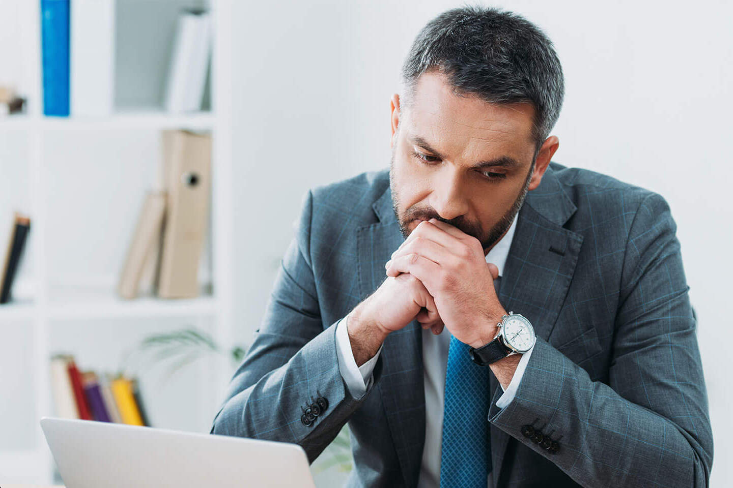 businessman thinking in office next to laptop